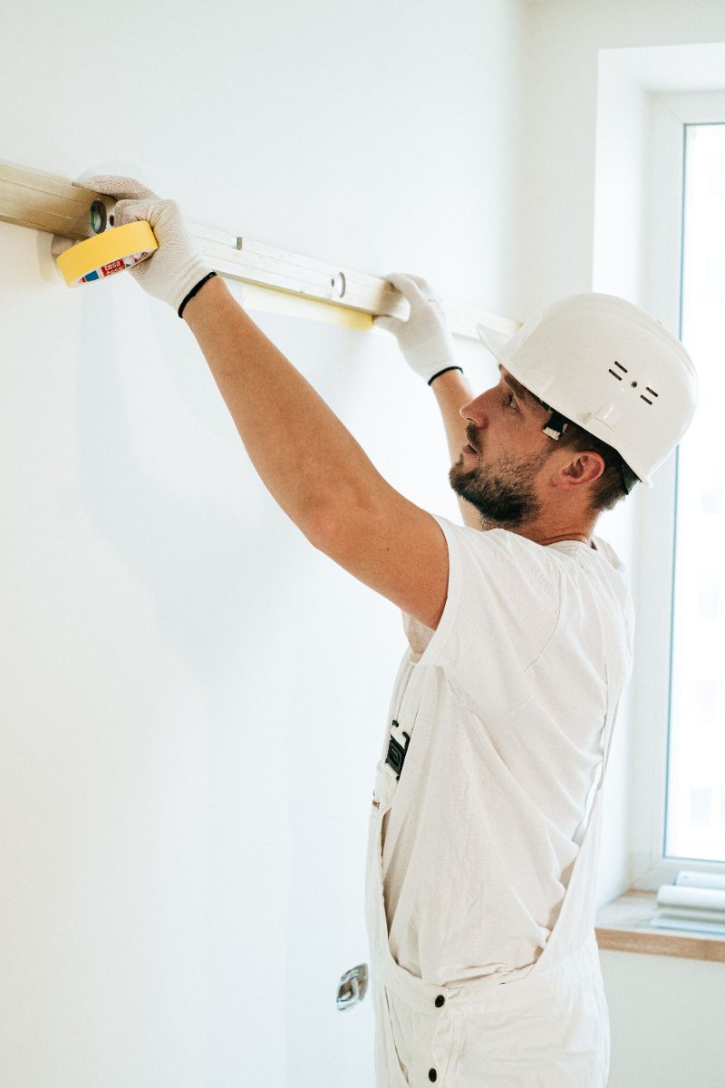 Tradesman leveling a line on a wall